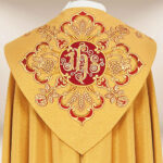 Capa bordada dorada con motivo IHS