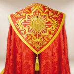 Capa pluvial roja IHS bordada